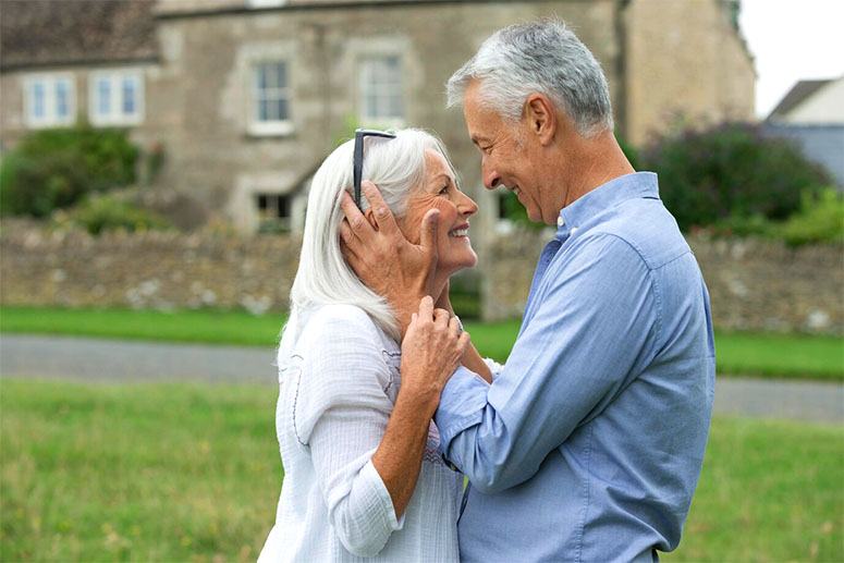 An old couple bend over outside