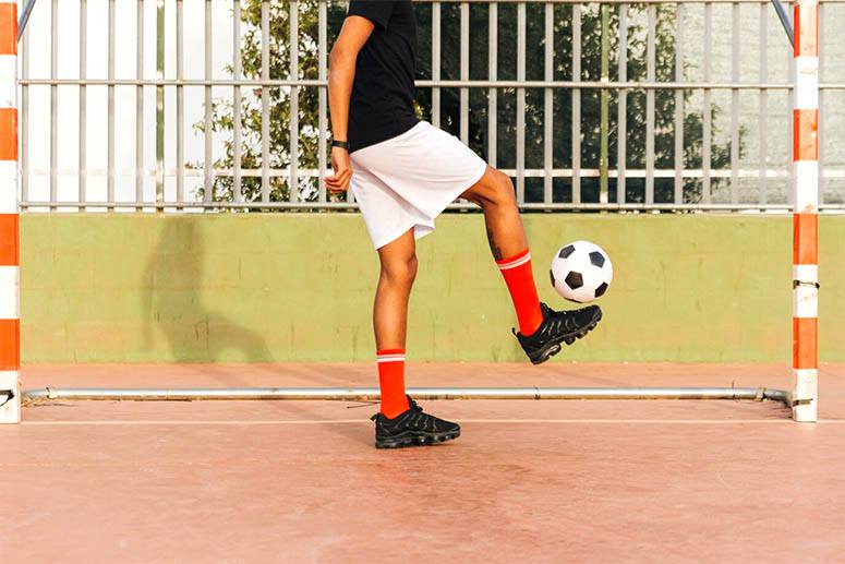 The boy is dribbling with a soccer ball 