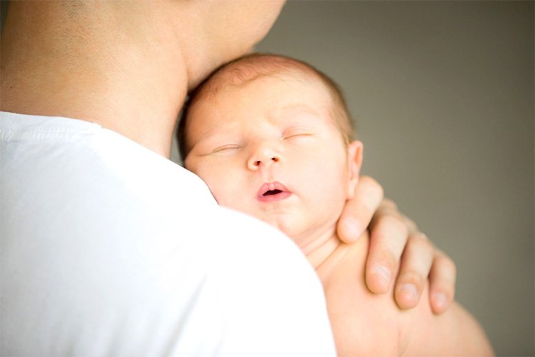 A baby hold by her mom