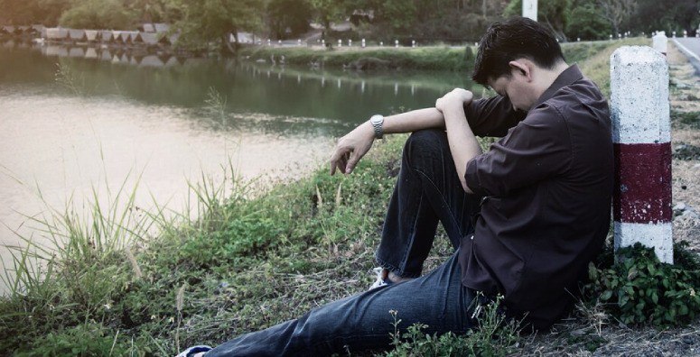 Depressed boy near lake