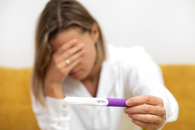 Desperate woman showing pregnancy test