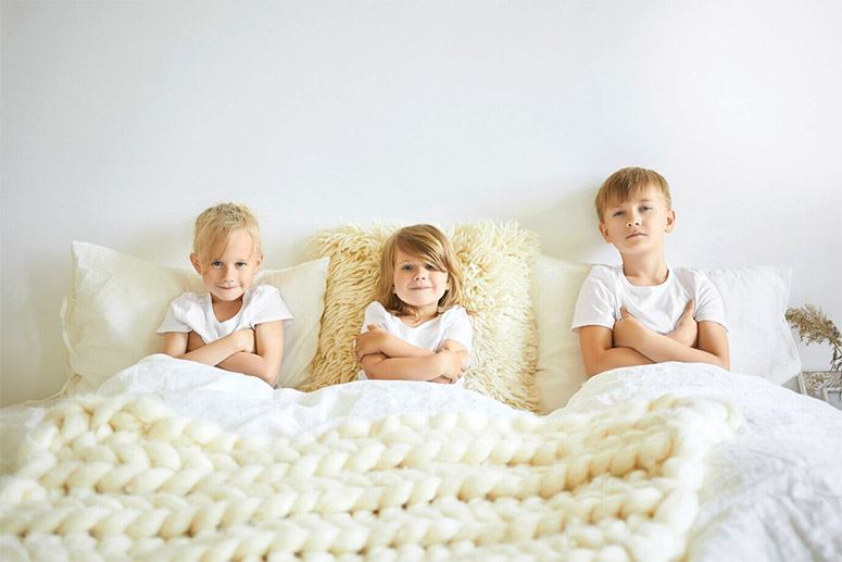 Triplets laying on the bed