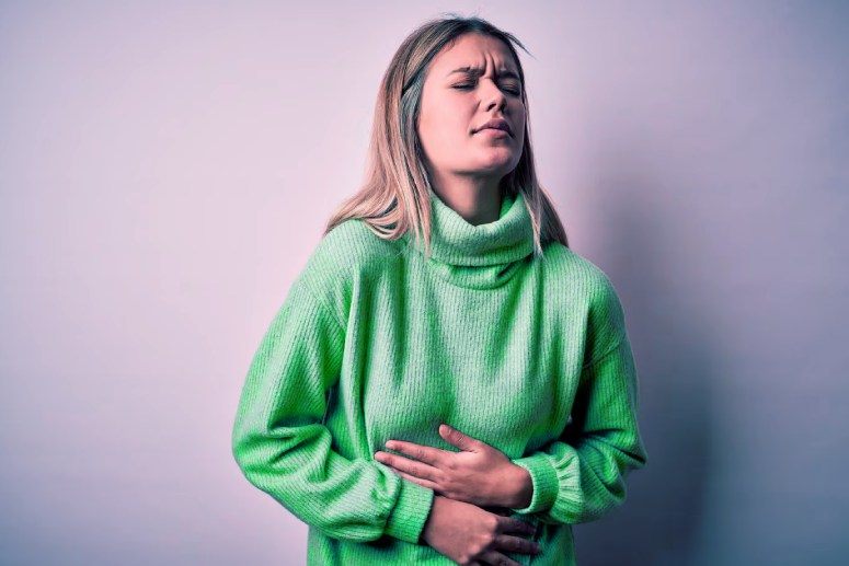 A woman feels abdominal pain caused by the pancreas