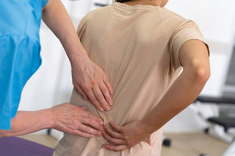 A chiropractor doing a procedure to woman's back