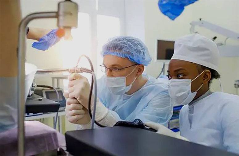 Two doctors perform a colonoscopy in the doctor's office