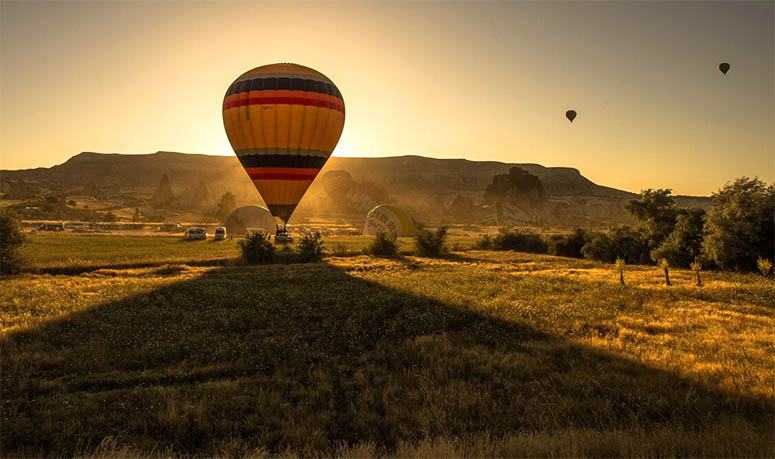 Hot air balloons in nature over sunset