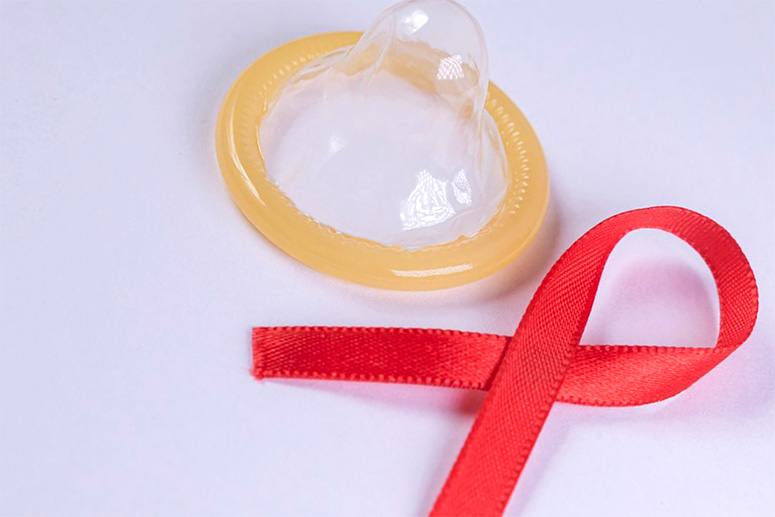 Condom and red tie on table