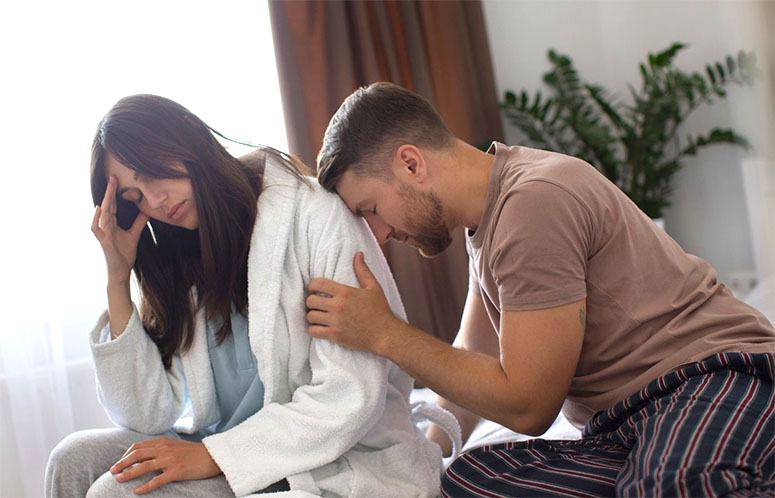 Disappointed man leaning on his wife's shoulder