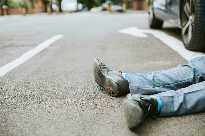 A man falls to the ground after being hit by a car