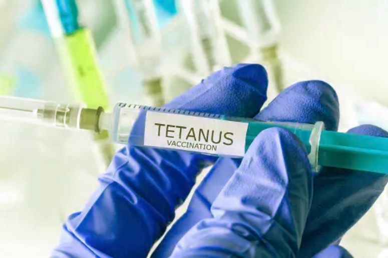 Hand holding a vaccine for tetanus