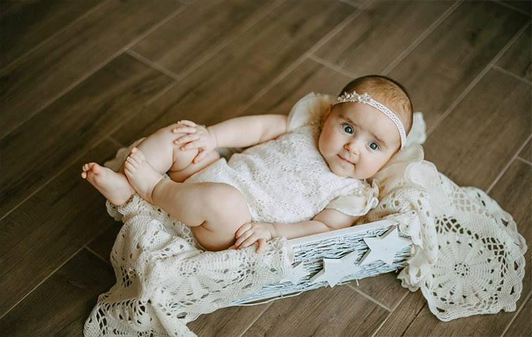 A baby girl is lying in a crib