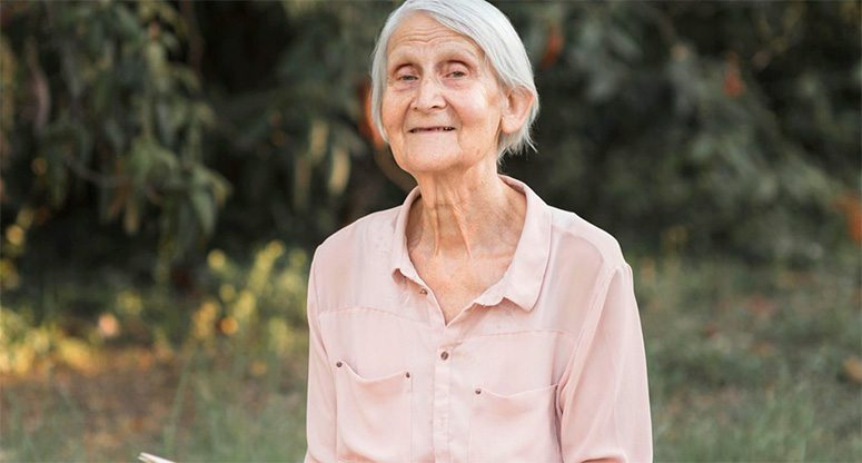 An very old woman pose for picture outside