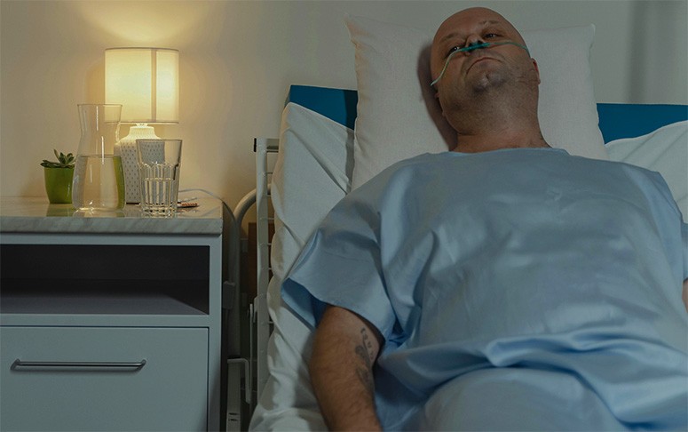 A hospital room with a man laying on a bed